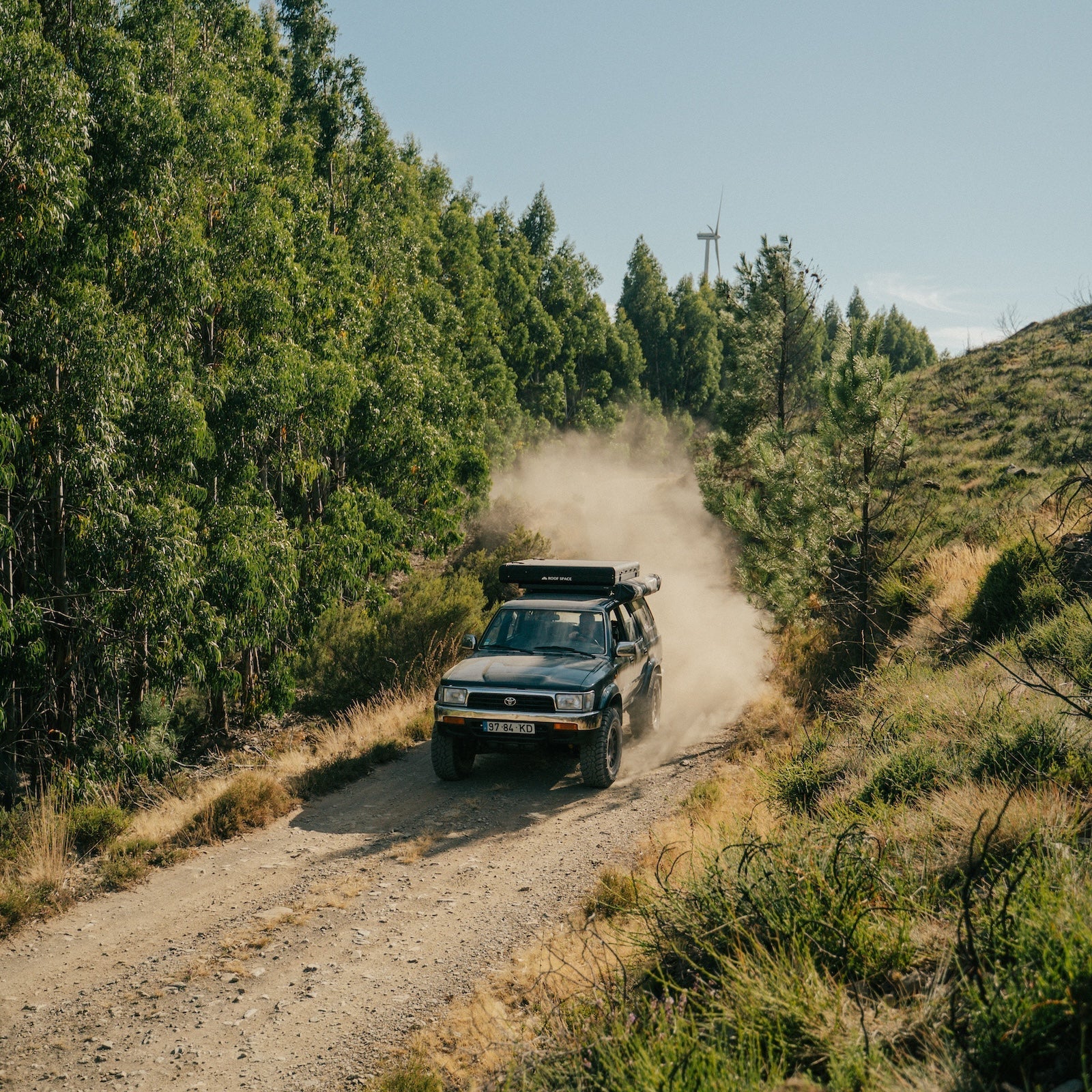 4x4 roulant sur un chemin de terre, une tente de toit 4 places Roof Space 4 est installée sur les barres de toit